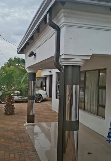 Polished chrome downpipe running down a white pillar